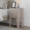 A bedside table next to a bed, with a lamp and e-reader on top, and a phone on the lower shelf. Produktbild-Vorschau