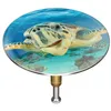 A close-up of a decorative bath plug with a turtle image. Produktbild-Vorschau