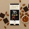 A Lindt Excellence 70% Cocoa Dark Chocolate bar is displayed with loose cocoa beans and pieces of chocolate. Náhled obrázku produktu