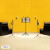 A music studio setup with amplifiers, microphones, and a music stand against a yellow wall. Podgląd zdjęcia produktu