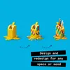 Three stages of a LEGO banana-shaped pencil holder being built and decorated, with text overlays. Podgląd zdjęcia produktu