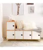A modular cube shelf unit with a bench seat, decorated with pillows and a blanket, in a room with framed art on the wall. Produktbild-Vorschau