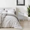 A bedroom scene with a bed and a nightstand. Produktbild-Vorschau