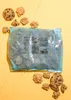 A bag of cookies and some loose cookies on a yellow background. Produktbild-Vorschau