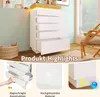 A white chest of drawers with a wooden top and LED lighting, shown in a room setting with a basket and a chair. Includes close-up shots highlighting features. Náhled obrázku produktu