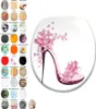 A collage of toilet seat designs, with a large image of a high-heeled shoe decorated with pink flowers and butterflies in the center. Náhled obrázku produktu