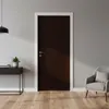 A dark brown door with a white frame, next to a gray armchair and a black console table with a plant and books, on a wooden floor. Produktbild-Vorschau