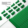 A collection of green pleated blind components and a section of the pleated blind itself, arranged on a white background. Produktbild-Vorschau