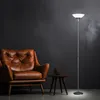 A brown leather armchair and a floor lamp are placed in a room with a dark gray wall. Produktbild-Vorschau
