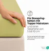 A hand is shown pressing down on a light green mattress topper, indicating its thickness and suitability for box spring beds with topper mattresses. Produktbild-Vorschau