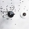 A top-down view of a moka pot, coffee beans, and a cup of coffee on a light gray background. Produktbild-Vorschau