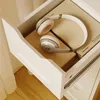 A close-up view of an open drawer containing a pair of white and gray headphones resting on top of two books. Produktbild-Vorschau