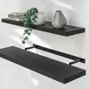 Two black floating shelves mounted on a white wall. The top shelf has books, a plant, and a vase. The bottom shelf is empty. Anteprima dell’immagine prodotto