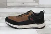 A side view of a brown and black sneaker. Voir les images du produit