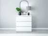 A white dresser with three drawers is shown against a light gray wall, with decorative items on top. Produktbild-Vorschau