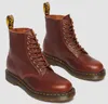 A pair of brown leather Dr. Martens boots. Produktbild-Vorschau