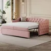 A pink upholstered daybed with a pull-out trundle bed is shown in a well-lit room with decorative molding on the walls. Produktbild-Vorschau
