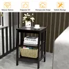 A dark brown, three-tiered side table with a vase of flowers, a cup and saucer, and books on its shelves, set against a striped brown and gray wall. Náhľad obrázku produktu
