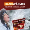 A woman in a winter hat blowing snow while holding hand warmers. Náhled obrázku produktu