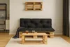 A living room setup with a pallet sofa and coffee table, featuring black cushions and a grey throw blanket. Produktbild-Vorschau