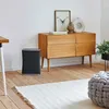 A modern living room with an air purifier, a wooden dresser, and a rug. Podgląd zdjęcia produktu