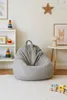 A child's room with a beanbag chair, toys, and artwork. Produktbild-Vorschau