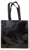 A black tote bag with black handles against a white background. Produktbild-Vorschau