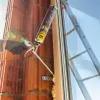 A person is using a can of expanding foam to seal a window frame during construction. Produktbild-Vorschau