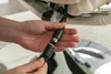 A person's hands are connecting two black electrical cables together, likely for a massage chair. Produktbild-Vorschau
