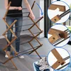 A person is demonstrating how to fold a wooden drying rack. Anteprima dell’immagine prodotto
