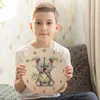 A young boy is holding a round wall clock with a koala illustration. Produktbild-Vorschau