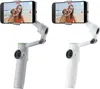 Two white camera gimbals with smartphones attached, showing a woman and a dog on a beach. Podgląd zdjęcia produktu