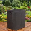 A dark brown polyrattan storage cube with a black top sits on a wooden deck in a lush garden setting with colorful flowers and greenery. Anteprima dell’immagine prodotto