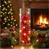 Rote Glasbrocken in einer Glasvase mit Lichterkette als festliche Weihnachtsdekoration vor einem Kam Produktbild-Vorschau