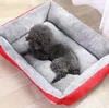 A small black poodle dog is resting comfortably in a red and gray dog bed. Anteprima dell’immagine prodotto