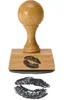 A wooden stamp with a lipstick kiss imprint on its base, shown above a separate imprint of the lipstick kiss. Produktbild-Vorschau