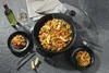 A paella dish is served in a party pan with a glass of white wine and a bottle of wine on the side. Anteprima dell’immagine prodotto