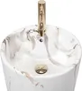 A close-up view of a marble-patterned sink with a gold faucet. Produktbild-Vorschau
