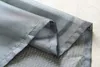 A close-up view of folded gray sheer curtains, showing the stitching and hem. Produktbild-Vorschau