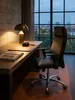 Der elegante schwarze Schreibtischstuhl steht einsatzbereit neben einem Stapel Bildbände und einer warm leuchtenden Messing-Tischlampe._#sku_BARSPM1.800# Produktbild-Vorschau