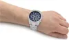 A man's wrist wearing a silver Maserati watch with a blue face. Produktbild-Vorschau