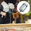 A person wearing white gloves is using a blue and black electric drill to bore a hole in a wooden plank. A small silver motor is shown in a circular inset on the right side of the image. Produktbild-Vorschau