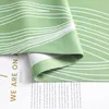 A close-up of a green curtain with white wavy lines, partially covering a white paper with text. Produktbild-Vorschau