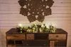 A rustic wooden dresser with a festive garland and lights draped across the top, set against a white wooden plank wall with a decorative jute rug hanging above. Produktbild-Vorschau