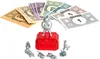 Monopoly game pieces and money are arranged on a white background. Voir les images du produit