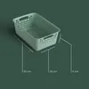 A green storage basket with dimensions indicated by lines and text. Voir les images du produit