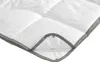 A close-up view of a white duvet with gray piping and visible snaps. Produktbild-Vorschau
