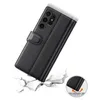 A black leather flip case for a smartphone is shown falling onto a cracked surface, illustrating its protective qualities. Produktbild-Vorschau