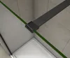 Close-up view of a shower enclosure corner, showing a gray metal support bar and a green glass edge against tiled walls and a white shower tray. Produktbild-Vorschau