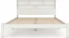 A white wooden bed frame with a slatted base and a headboard with shelving, shown from the front. Anteprima dell’immagine prodotto